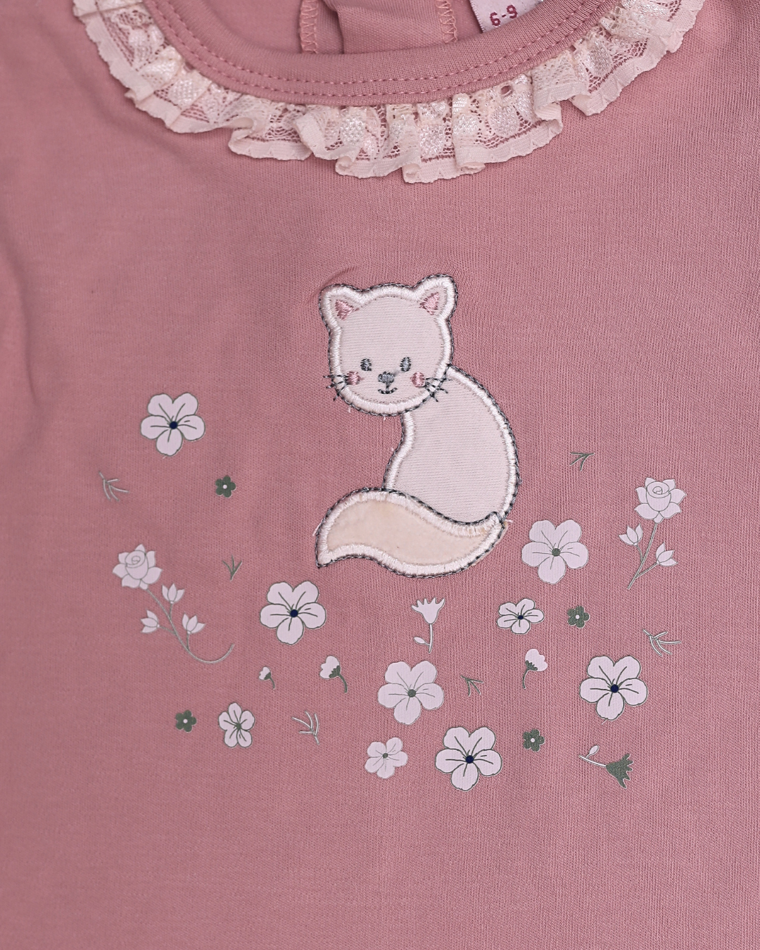 Close-up of dusty rose top with embroidered white fox surrounded by flowers and lace collar