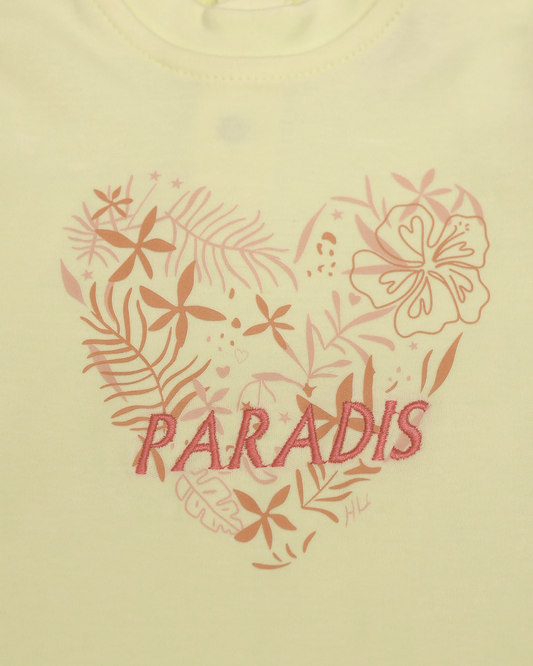Close-up of Paradis tropical floral heart embroidery with hibiscus and palm leaves on yellow baby top